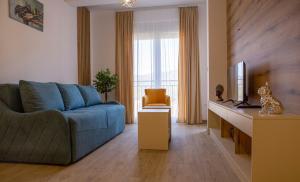 sala de estar con sofá azul y TV en Apart Hotel Gondola Kolasin, en Kolašin
