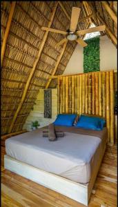 Santa RosaにあるCabinas de Lou Eco Lodge TAMARINDOの天井ファン付きの客室のベッド1台分です。