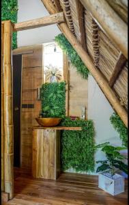 een badkamer met een kom op een tafel met planten bij Cabinas de Lou Eco Lodge TAMARINDO in Santa Rosa