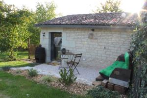 a small house with a green couch in a yard at Studio confort, charme & tranquilité "Le Grenier" in Beaumont