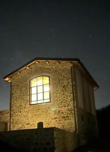 - une fenêtre sur le côté d'un bâtiment en pierre la nuit dans l'établissement Fuoridicampo, à Roncovetro