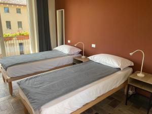 twee bedden in een kamer met een raam bij Fuoridicampo in Roncovetro