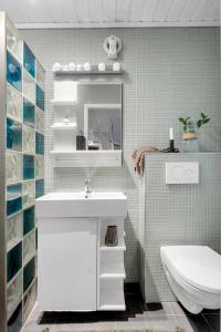 a bathroom with a white sink and a toilet at Cozy and spacious apartment in city centre in Tromsø +19 photos