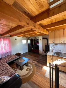 eine Küche und ein Wohnzimmer mit einem Sofa und einem Tisch in der Unterkunft Vikendica Krčmarice in Banja Luka