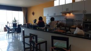 Dos mujeres sentadas en un mostrador en una cocina en ArenaNorte en Pimentel