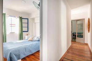 1 dormitorio con cama con sábanas azules y ventana en Habitaciones privadas en Ñuñoa Estadio Nacional en Santiago