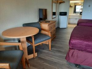 een kamer met een bureau, een tafel en een bed bij Centralia Inn in Centralia