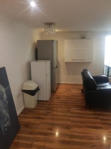 a living room with a refrigerator and a couch at RAYAN'S LODGE STRATFORD in London