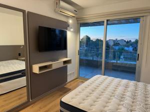 - une chambre avec un lit, une télévision et une fenêtre dans l'établissement Departamento Adrogue Cordero Plaza Wifi 60m2 piscina zona restaurants y bares, à Adrogué