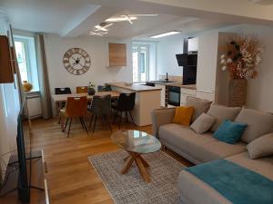 a living room and kitchen with a couch and a table at L'Escale Portaise in Port-en-Bessin-Huppain