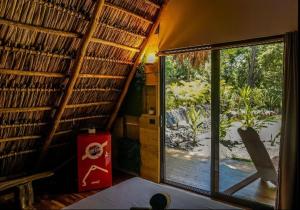 a room with a window and a view of a yard at Cabinas de Lou Eco Lodge TAMARINDO in Santa Rosa
