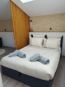 a bed with two pairs of towels on it at Studio à la campagne, proche Futuroscope in Beaumont