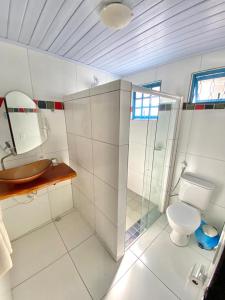 uma casa de banho com um WC e uma cabina de duche em vidro. em Pousada Praias do Norte em São Miguel dos Milagres