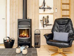 ロンストラップにある8 person holiday home in Hj rringのリビングルーム(革張りの椅子、暖炉付)