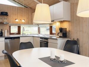 ロンストラップにある8 person holiday home in Hj rringのキッチン(白いテーブル、椅子付)