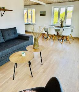 Skøn villalejlighed i Skagen med terrasse og tæt på centrum في سكاغن: غرفة معيشة مع أريكة وطاولات