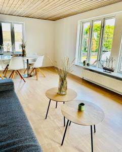 een woonkamer met 2 tafels en een bank bij Skøn villalejlighed i Skagen med terrasse og tæt på centrum in Skagen