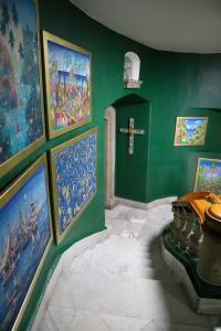uma sala verde com pinturas e uma cruz na parede em The Tower of Alebrijes in San Angel Inn em Cidade do México