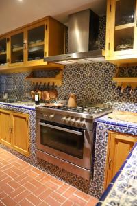uma cozinha com um fogão de aço inoxidável forno superior em The Tower of Alebrijes in San Angel Inn em Cidade do México
