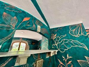 um quarto com uma parede azul com um mural de folhas em The Tower of Alebrijes in San Angel Inn em Cidade do México