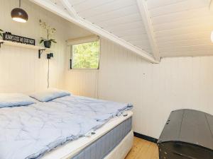 a bedroom with a bed in a room with a window at Holiday home Tranekær XVIII in Tranekær