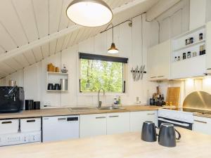 une cuisine avec des placards blancs et une fenêtre dans l'établissement Holiday home Tranekær XVIII, à Tranekær
