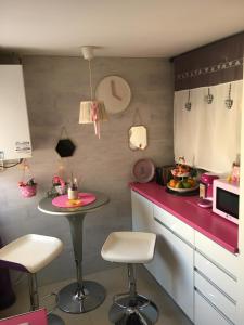 a small kitchen with a table and two stools at Habitación particular,baño compartido in Zaragoza