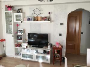 a living room with a television on a white entertainment center at Habitación particular,baño compartido in Zaragoza