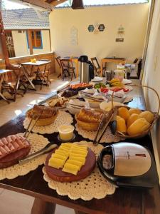 a table with cheese and other foods on it at Brisa da Serra Hotel Pousada Pirenopolis in Pirenópolis