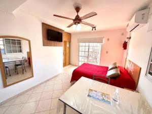 a living room with a red bed and a table at Los Preferidos in Colón