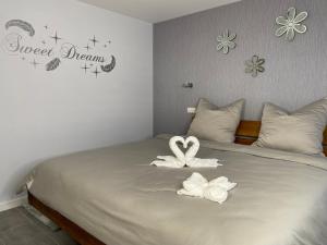 a bed with two white towels on top of it at Vulkanoase Eifel - Wellness in Oberstadtfeld