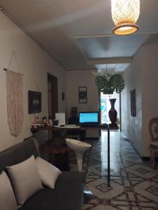 sala de estar con sofá y escritorio con ordenador portátil en Hostal El Marial e, en Marinilla