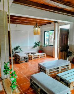 a room with two beds and a living room with plants at The Temple III, Mindo in Mindo