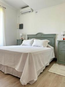 1 dormitorio con 1 cama blanca grande y muebles verdes en Los Narcisos en San Antonio de Areco