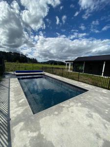 uma piscina num quintal com uma cerca em Woodside Bed and Breakfast em Greytown