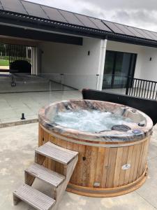 a large wooden hot tub with a pair of steps at Woodside Bed and Breakfast in Greytown