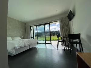 a bedroom with a bed and a balcony with a television at Woodside Bed and Breakfast in Greytown