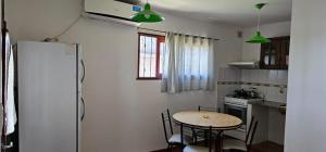 a small kitchen with a table and a refrigerator at Hospedaje Resiliencia in Cordoba