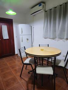 a dining room with a table and chairs and a refrigerator at Hospedaje Resiliencia in Cordoba
