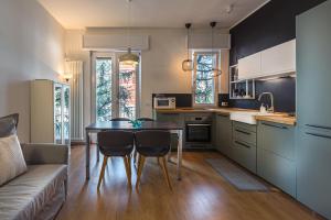 eine Küche mit einem Tisch, Stühlen und einem Sofa in der Unterkunft Max's House in Mailand