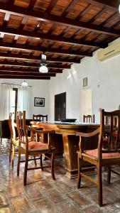 een eetkamer met een grote houten tafel en stoelen bij Los Narcisos in San Antonio de Areco