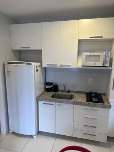 a kitchen with a white refrigerator and a microwave at Flat para 4 pessoas em Boa Viagem com Piscina, Wifi 500Mbps, localizado a 350 metros da Praia in Recife