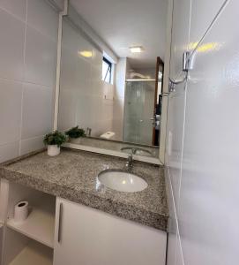 a bathroom with a sink and a mirror at Flat para 4 pessoas em Boa Viagem com Piscina, Wifi 500Mbps, localizado a 350 metros da Praia in Recife