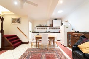 a kitchen and dining room with a table and a refrigerator at Snow-white's 2 bedroom City heart Cottage in Perth 6000 in Perth