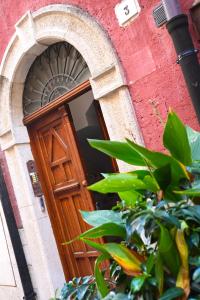 una puerta de madera en un edificio de ladrillo rojo en Dimora Notar Domenico -GRAVINA IN PUGLIA-, en Gravina in Puglia