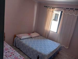 a small bedroom with a bed and a window at Casa disponível para diária, 300m do mar casa sozinha no terreno in Matinhos