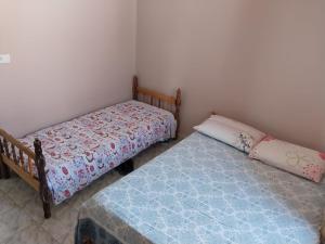 two beds sitting next to each other in a bedroom at Casa disponível para diária, 300m do mar casa sozinha no terreno in Matinhos