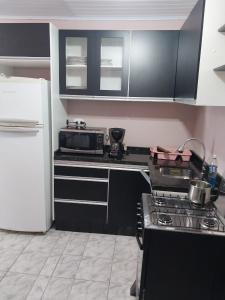 a kitchen with a stove and a refrigerator at Casa disponível para diária, 300m do mar casa sozinha no terreno in Matinhos