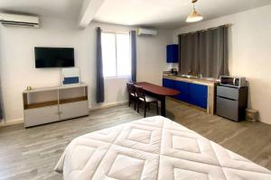 a bedroom with a bed and a table and a kitchen at Habitación loft en la Huasteca in Ciudad Valles