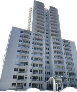 a tall white apartment building with people standing in front of it at Departamento nuevo en reñaca alto 2 dormitorios in Viña del Mar